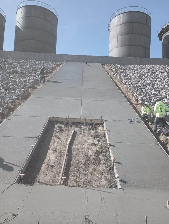 A group of construction workers are working on a concrete walkway.
