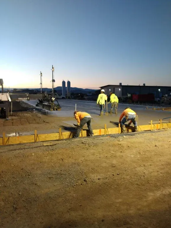 A group of construction workers are working on a concrete surface