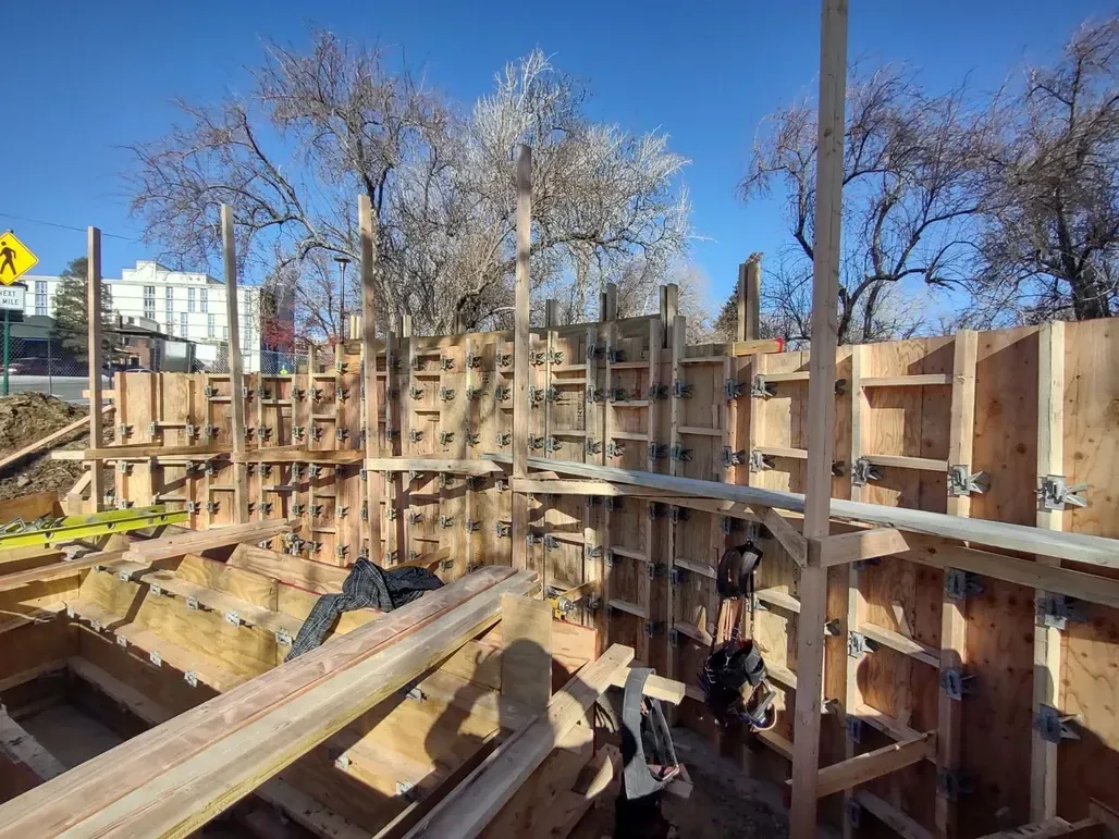 A construction site with a yellow crosswalk sign in the background.