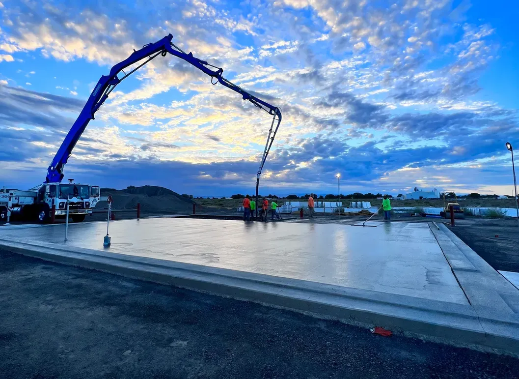 A concrete pump is being used to pour concrete on a construction site.