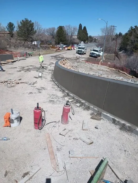 A concrete wall is being built on the side of a road