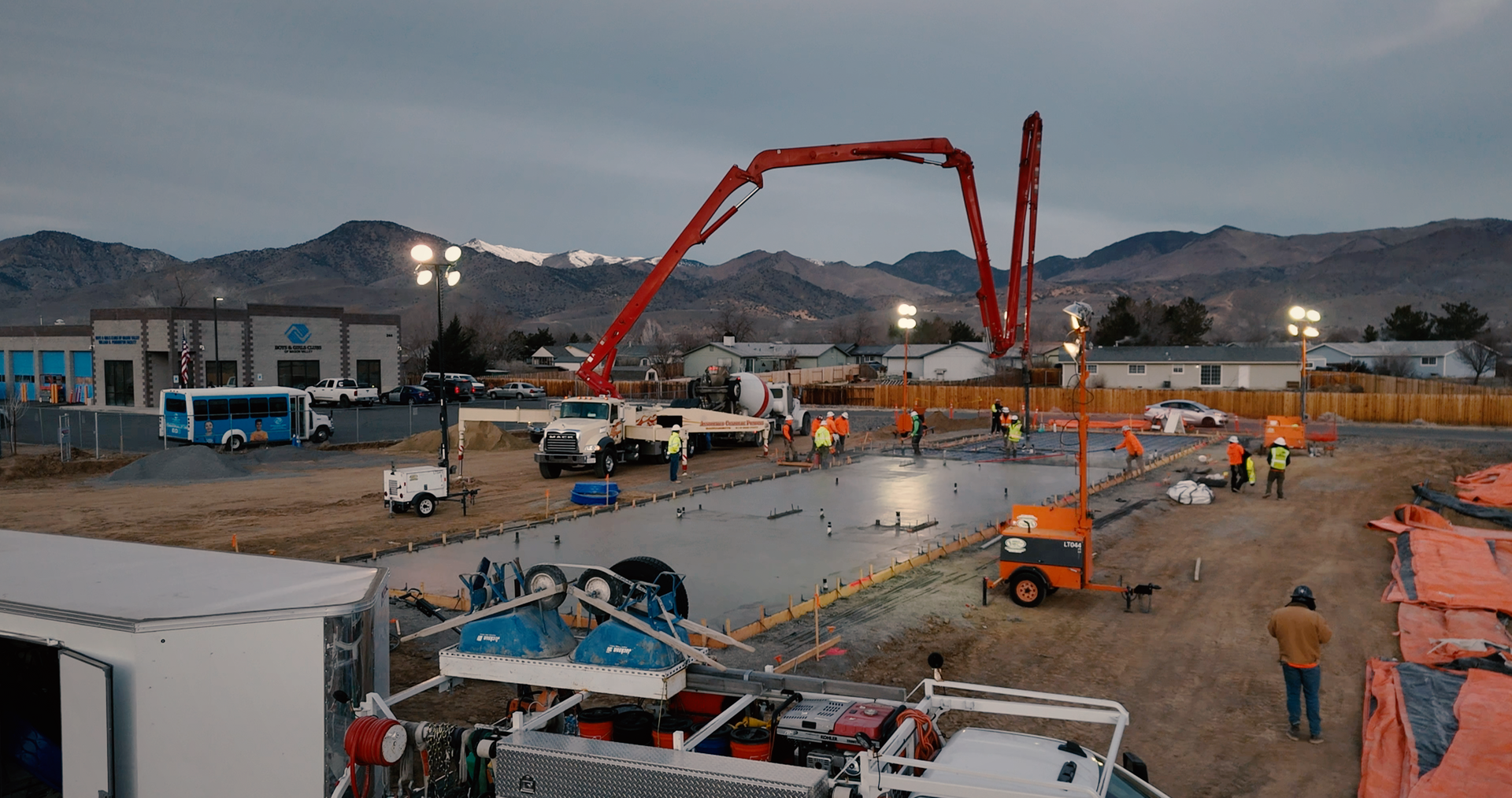 Two men are working on a concrete floor with a broom. Two men are working on a concrete floor with a broom.