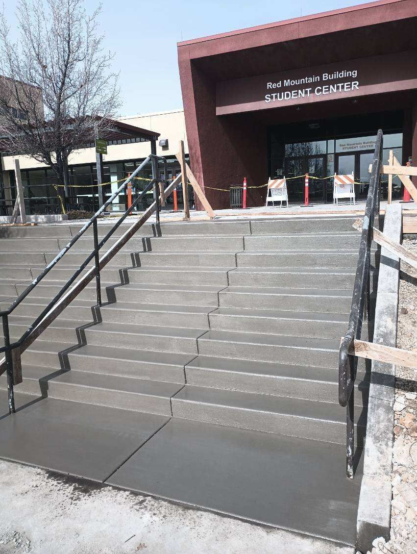 A set of concrete stairs leading up to a building under construction.