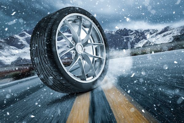 Car tire skidding on snow-covered road; mountains in the background. | Torque European Car Care