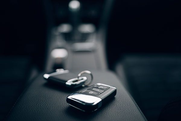Car keys resting on a black console in a vehicle. | Torque European Car Care