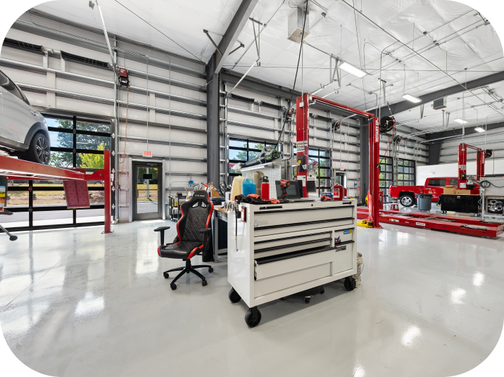 Brightly lit auto shop interior with tools, lifts, and vehicles. | Torque European Car Care