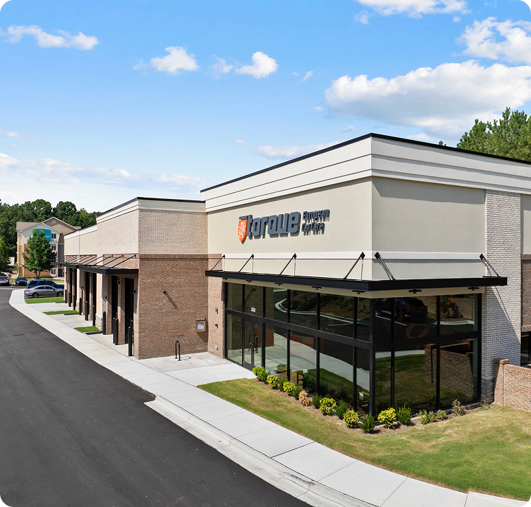 Storage Sense facility with a storefront, black awning, and a cloudy blue sky. | Torque European Car Care