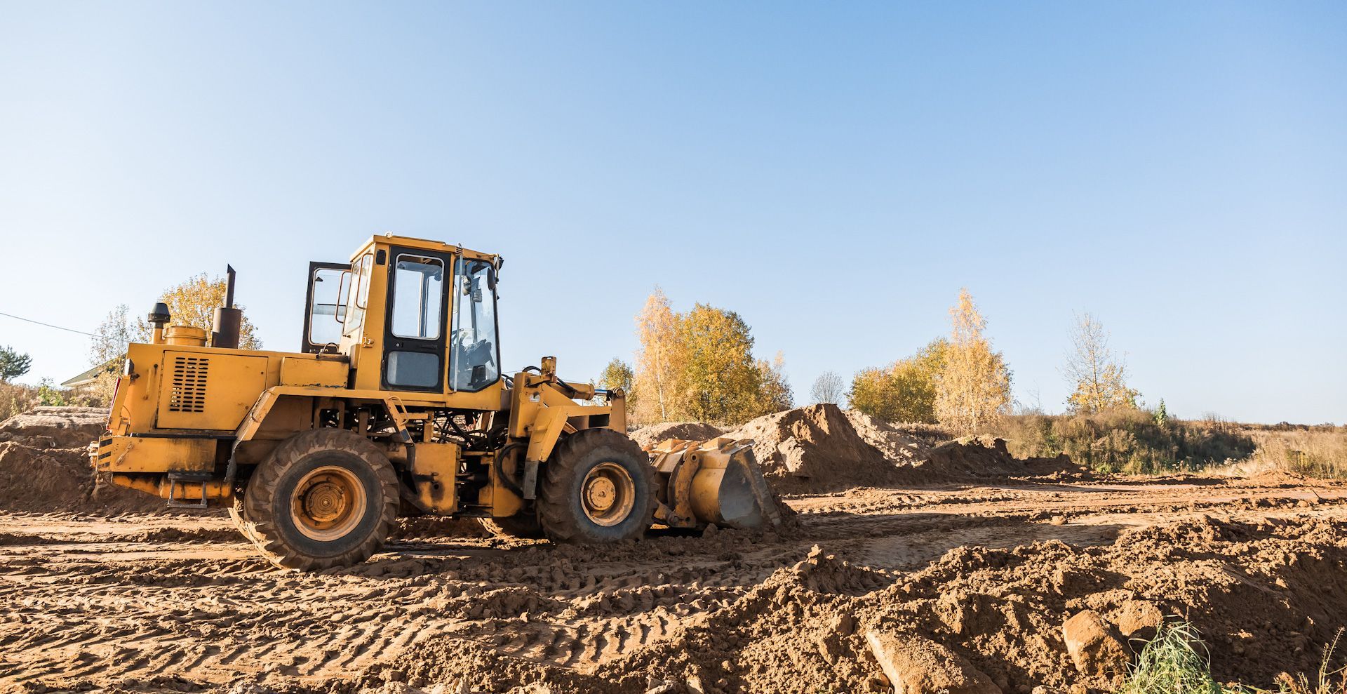 A yellow bulldozer is moving dirt on a construction site.