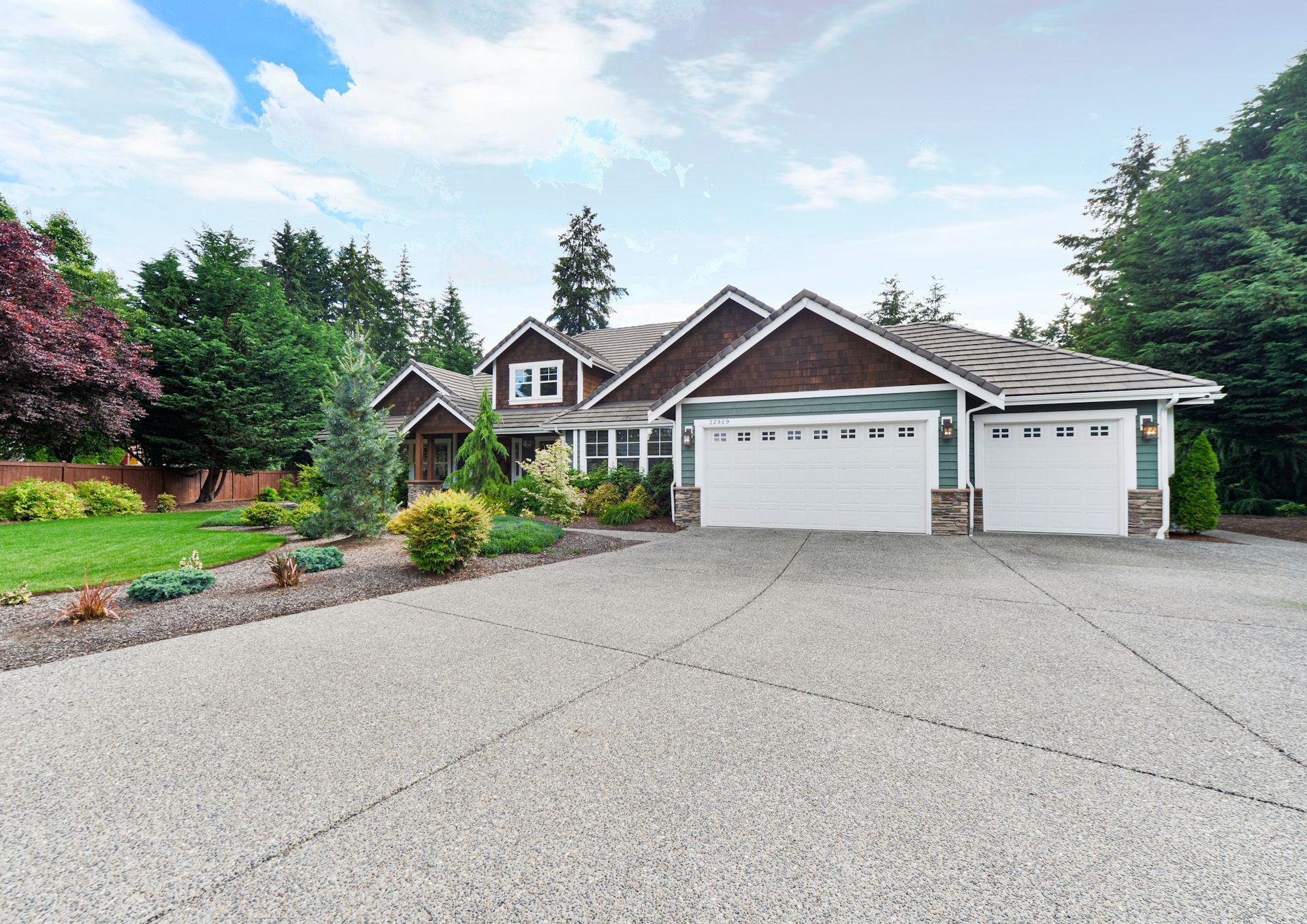 A large house with two garage doors and a driveway