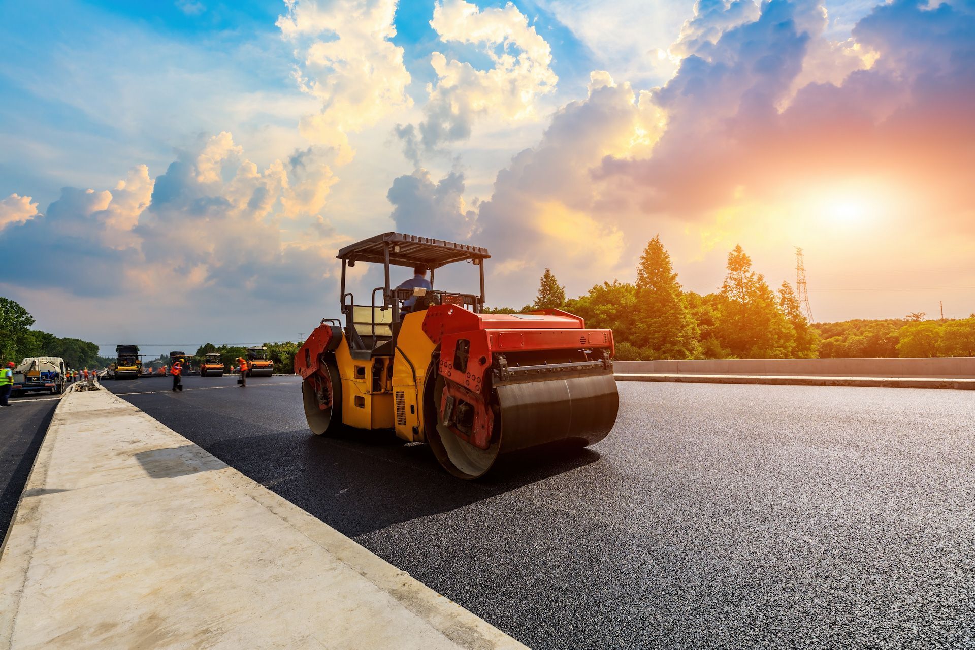 A roller is rolling asphalt on a road under construction.