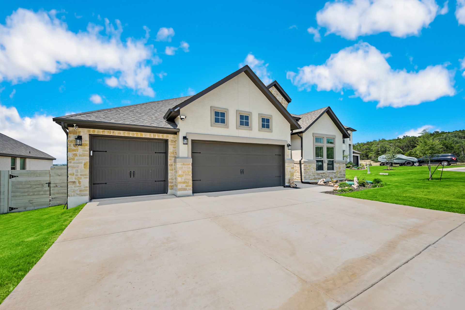 A large house with two garages and a driveway in front of it.