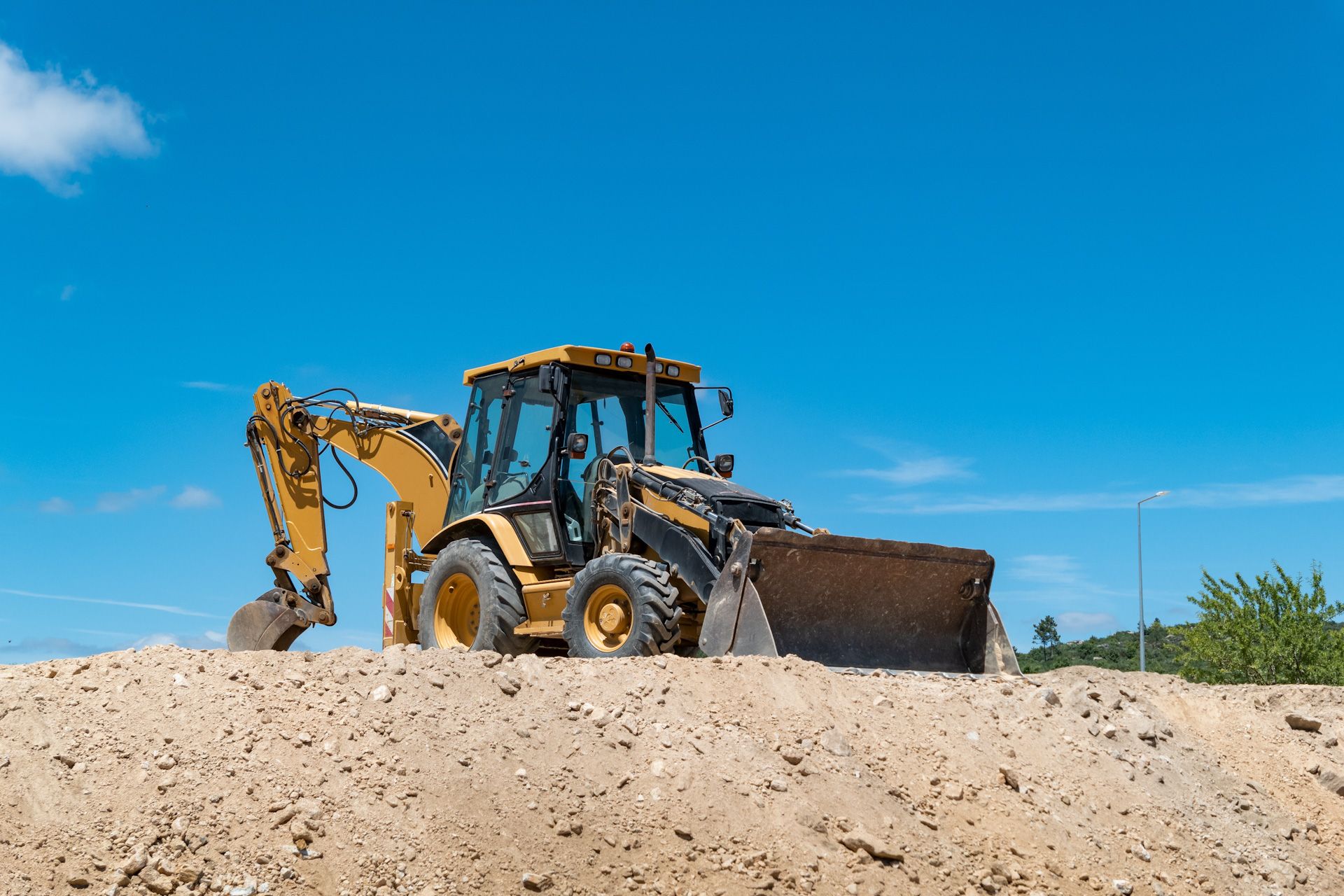 A bulldozer is sitting on top of a pile of dirt.