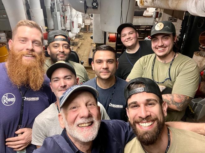 A group of men are posing for a picture together in a room.