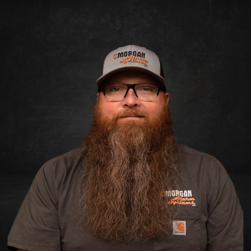 A man with a long beard wearing a hat and glasses.