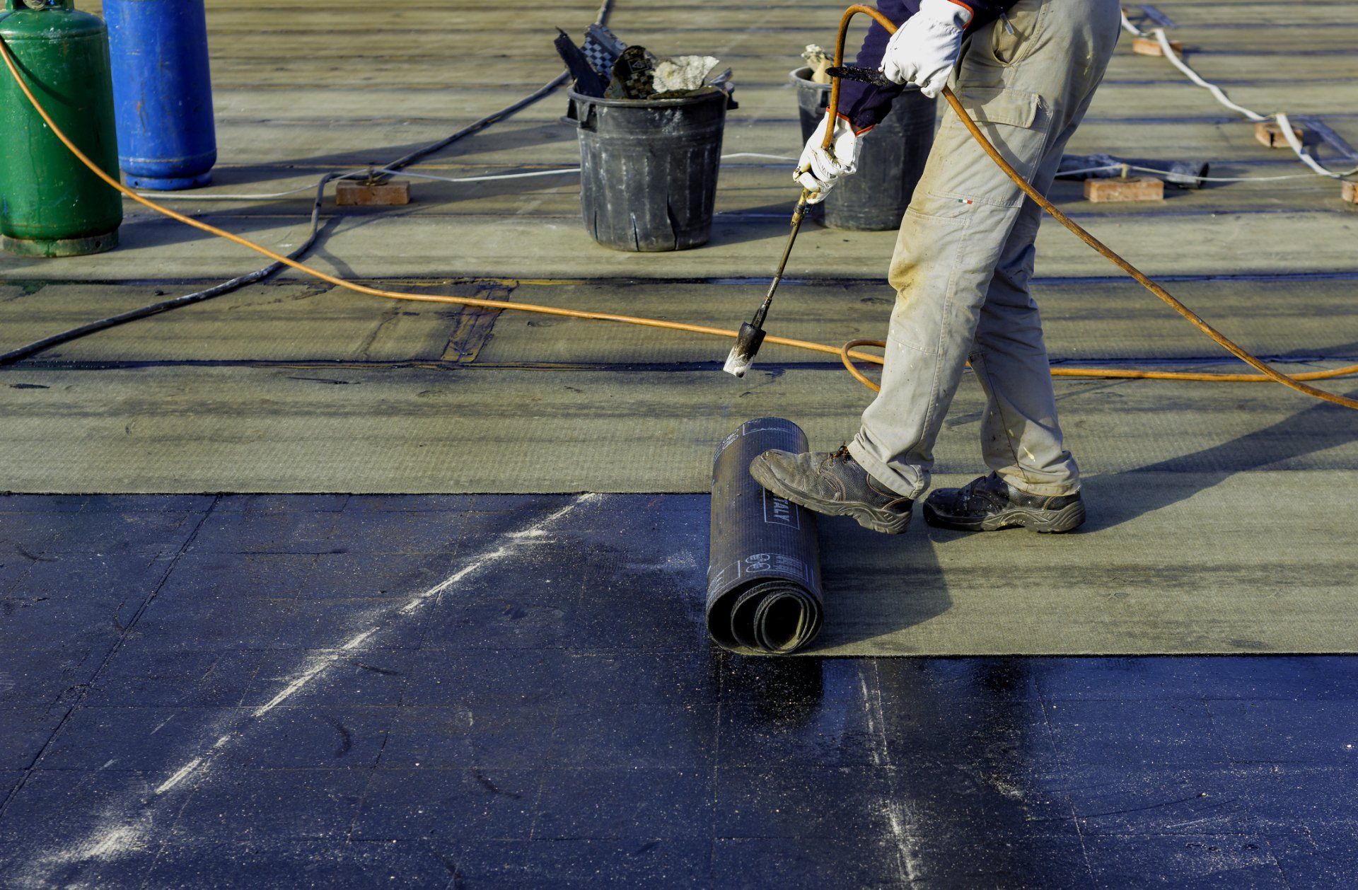 Worker Preparing Bitumen Roofing Felt Roll — Coral Springs, FL — Pro Roofing Services
