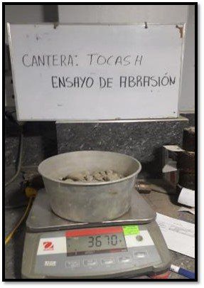 Un cuenco de hormigón está en una balanza debajo de un cartel que dice cantera.