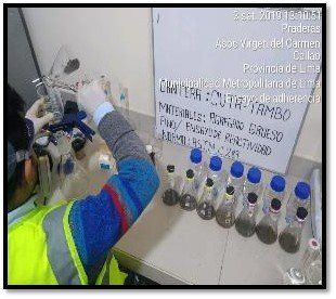 Una persona está trabajando en un laboratorio con botellas y una pizarra blanca.