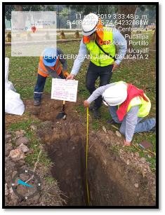 Un grupo de hombres está midiendo un agujero en el suelo.