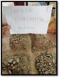 Una persona sostiene un trozo de papel sobre una pila de rocas.