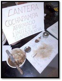 Una mesa con un cartel y un cuenco de tierra encima.
