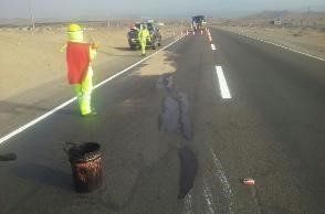 Un grupo de personas está de pie al costado de una carretera.