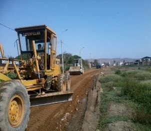 Un tractor oruga avanza por un camino de tierra.