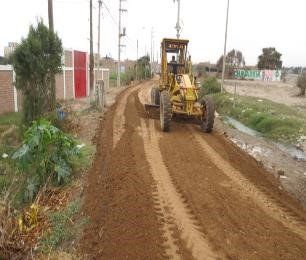Un tractor amarillo conduce por un camino de tierra.