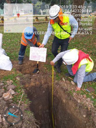 Un grupo de trabajadores de la construcción está midiendo un agujero en el suelo.
