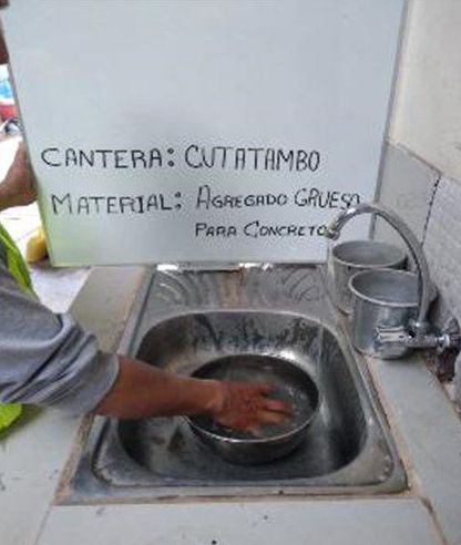 Una persona está lavando un recipiente en un fregadero.