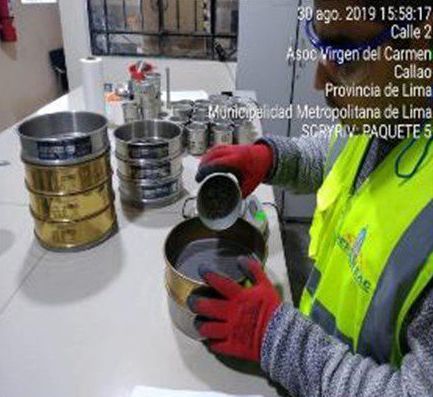 Una persona con un chaleco amarillo está vertiendo algo en un colador.