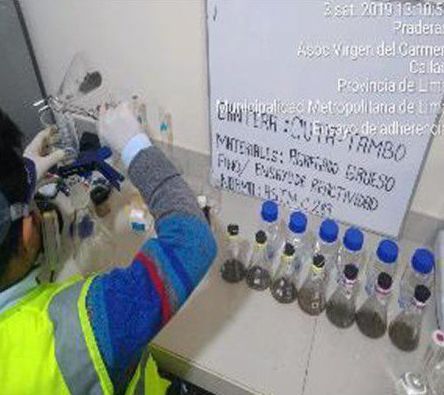 Una persona está parada frente a una pizarra blanca con botellas encima.