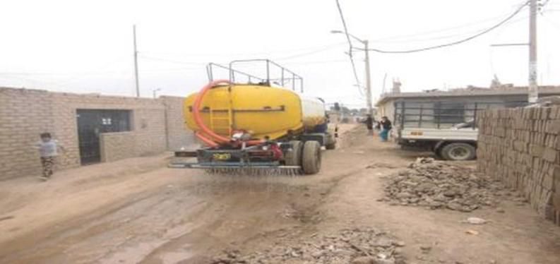 Un camión amarillo circula por un camino de tierra.
