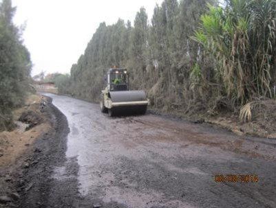 Una apisonadora avanza por un camino de tierra.