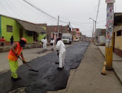 Un grupo de personas está limpiando una calle con una escoba.