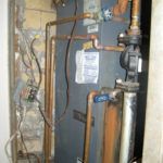 A room with a lot of pipes and wires on the wall.