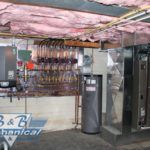 A room with a stove and a water heater in it.