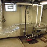 A basement with a furnace and a window.