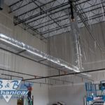 A large room with a lot of pipes hanging from the ceiling.