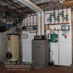 A basement with a water heater and a boiler.