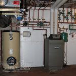 A room with a water heater and a boiler in it.