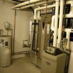 A room with a water heater and a boiler in it.