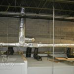 A bunch of pipes are hanging from the ceiling of a building.