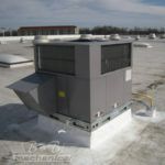 A large air conditioner is sitting on top of a roof.