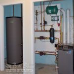 A room with a water heater and a furnace in it.