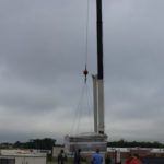 A crane is lifting a large object in the air.