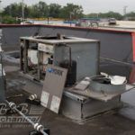 A broken air conditioner is sitting on top of a roof.