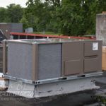 A large air conditioner is sitting on top of a roof.