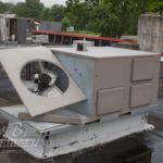 A box with a fan on top of it is sitting on top of a roof.