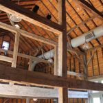 The inside of a barn with wooden beams and a ceiling.