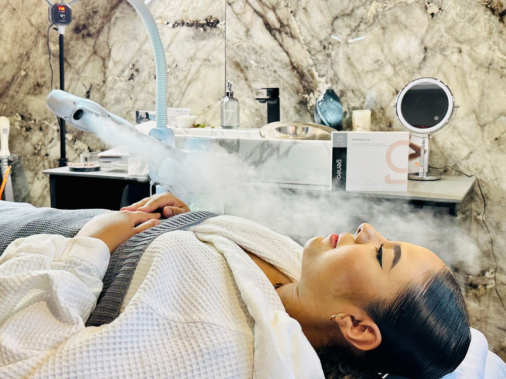 A woman is laying on a bed with steam coming out of her face.